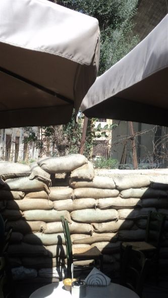 Udendørsserveringsområdet på cafe klods op af bufferzonen og grænseposten på Ledra mellem den græske og den tyrkiske del af Nicosia. Med udsigt til forladt og tom gade. En spøgelsesgade siden delingen i 1974.
