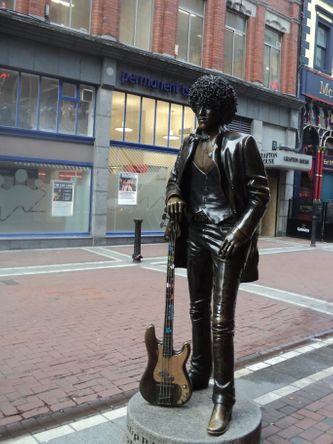 Phil Lynnot, frontfiguren i Thin Lizzy, i bronze med sin bas på Harry St. i Dublin. Skulptur af Paul Daly fra 2005.